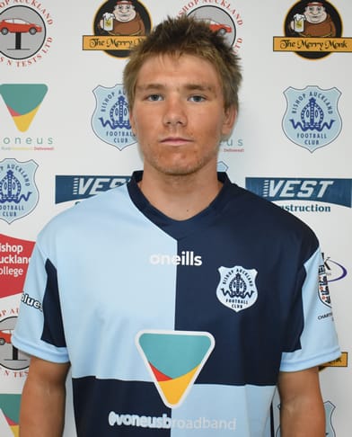 Bishop Auckland FC player in home and away kit, standing against club sponsorship backdrop, showcasing local football club's team gear and sponsorship, promoting UK football teams.