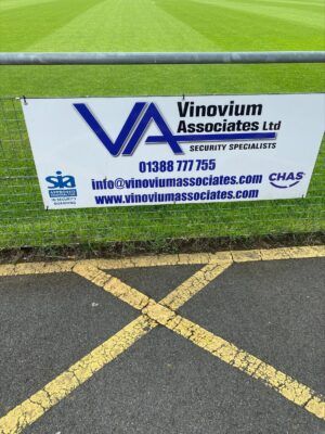 Vinovium Associates Ltd security sign at Bishop Auckland FC stadium, advertising security services and contractors.