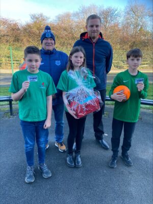 Young football players receiving awards at Bishop Auckland FC youth match celebration.