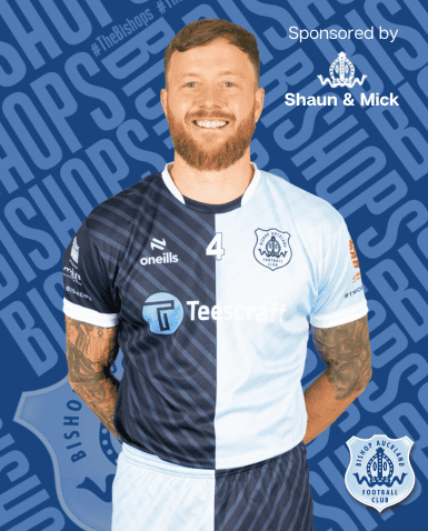 Professional Bishop Auckland FC player wearing team kit on the pitch, showcasing club pride and sponsorship branding.