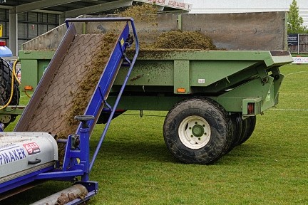 Heavy-duty turf maintenance equipment and team vehicles at Bishop Auckland FC's football ground, showcasing their commitment to pitch quality and matchday readiness.
