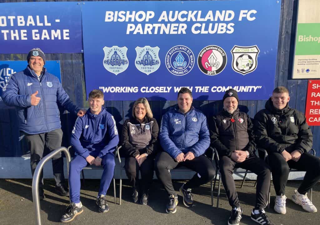 Bishop Auckland FC team members posing outdoors at the club's premises, showcasing community engagement and team spirit at Bishop Auckland FC.