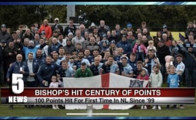 Bishop Auckland FC celebrating centenary milestone with players and supporters team photo on the football pitch.