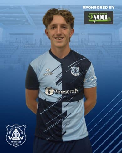 Ben Jordison wearing Bishop Auckland FC football kit, standing in an indoor sports facility, smiling at the camera.